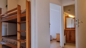A bunk bed with a ladder, a wooden door, and a mirror in a room with wooden flooring. - 2-room apartment with cabin - 6 ppl - Near slopes (Le Dévoluy)