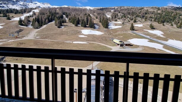 Eine Berglandschaft mit einem Skigebiet, einschließlich Seilbahnen, Pisten und schneebedeckten Flächen.