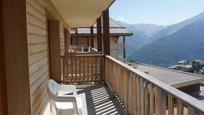 Un balcon en bois offrant une vue sur les montagnes.