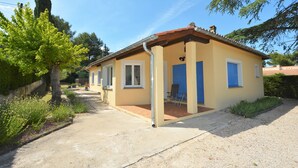 A small, single-story house with a tiled roof and a covered porch. - Charming villa with private pool in a peaceful, relaxing setting. (Comps)