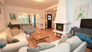 A living room with a sofa, armchair, and a fireplace. - Charming villa with private pool in a peaceful, relaxing setting. (Comps)