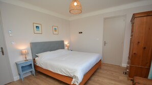 A bedroom with a bed, bedside tables, a wardrobe, and a hanging light fixture. - Charming villa with private pool in a peaceful, relaxing setting. (Comps)
