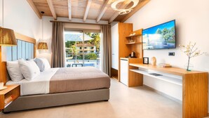 Una habitación de hotel moderna con cama, escritorio, televisión y vistas al balcón.