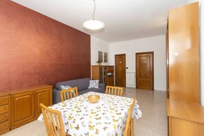 Un comedor con una mesa, sillas, un sofá y un armario.