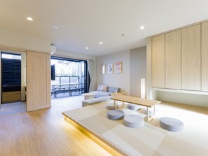 A modern living room with a sofa, coffee table, and tatami mats.