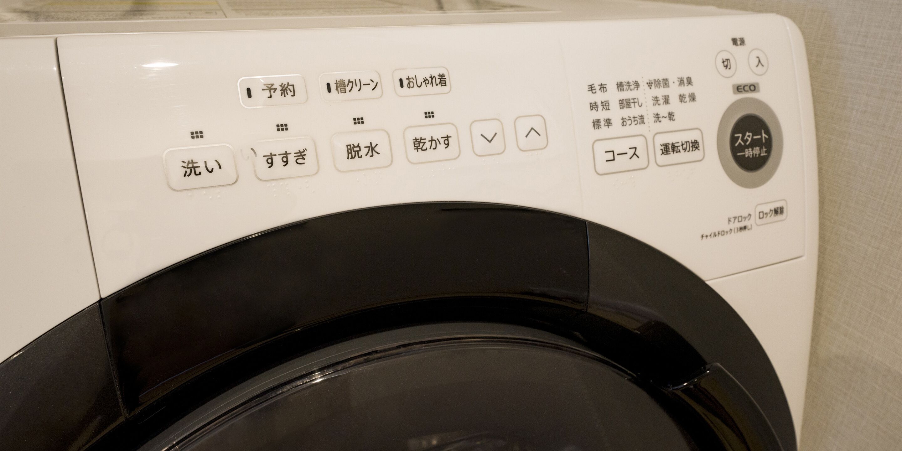A front view of a washing machine with control panel and buttons.