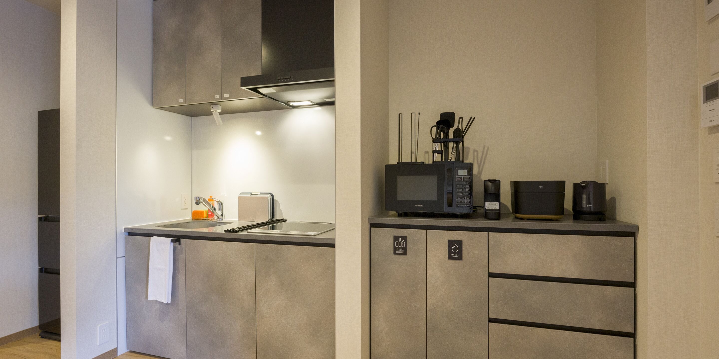 A modern kitchen with a built-in microwave, toaster, and coffee maker on the countertop.