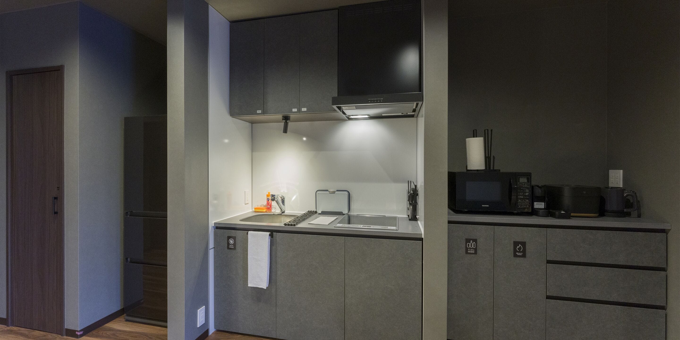 A compact kitchen with a built-in microwave, a sink, and a stove.