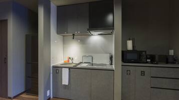 A compact kitchen with a built-in microwave, a sink, and a stove.