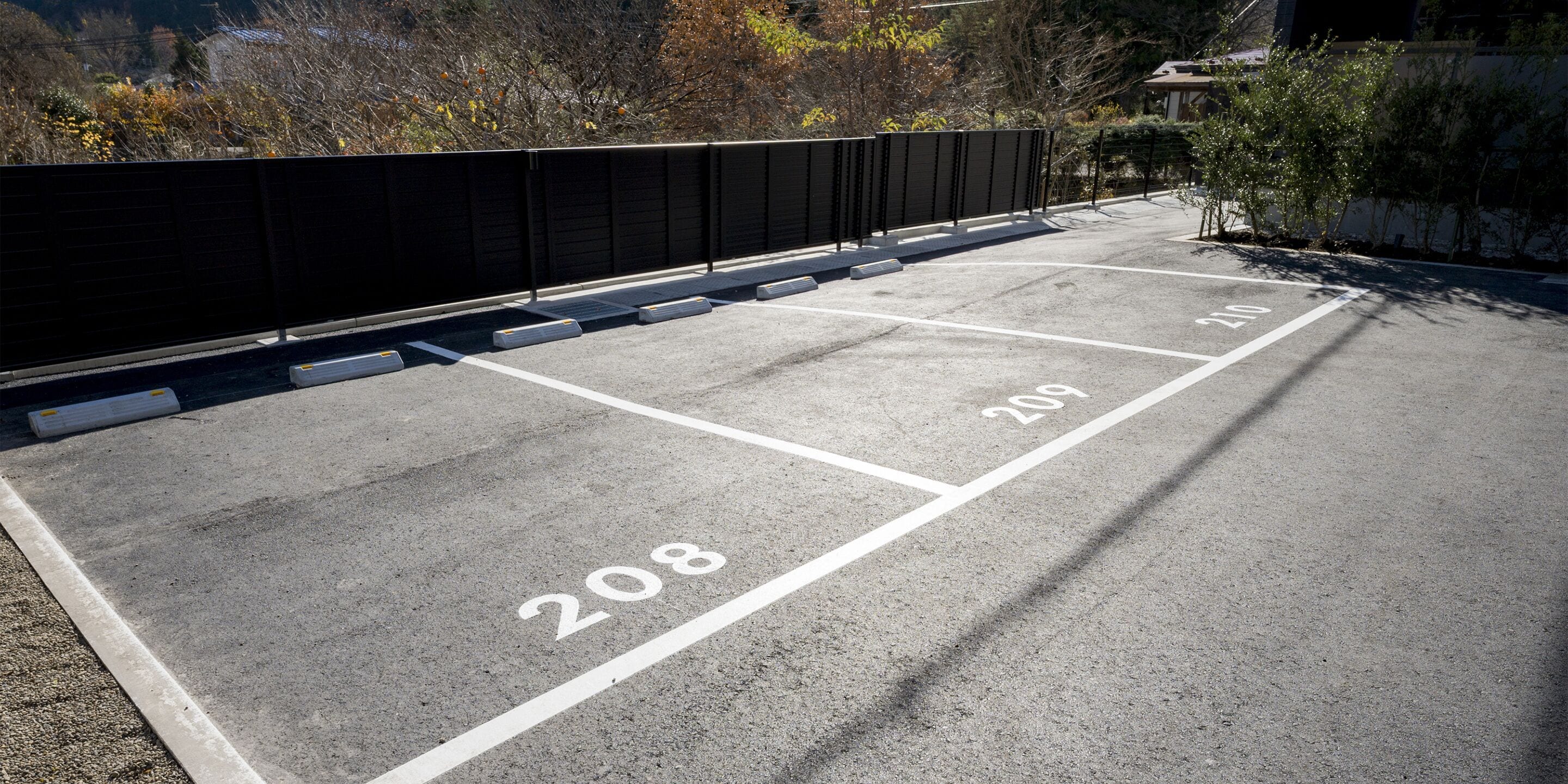 Un estacionamiento con espacios claramente delimitados, incluyendo los números 208 y 209.