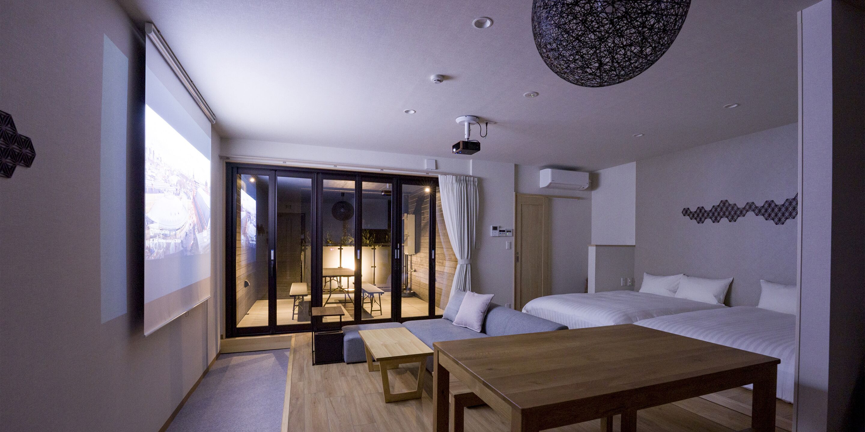 Une chambre moderne avec un grand lit, une table en bois et un balcon offrant une vue agréable.