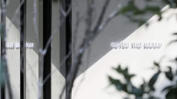 A modern building facade with vertical lines and a sign reading "HOTEL THE LEBEN".