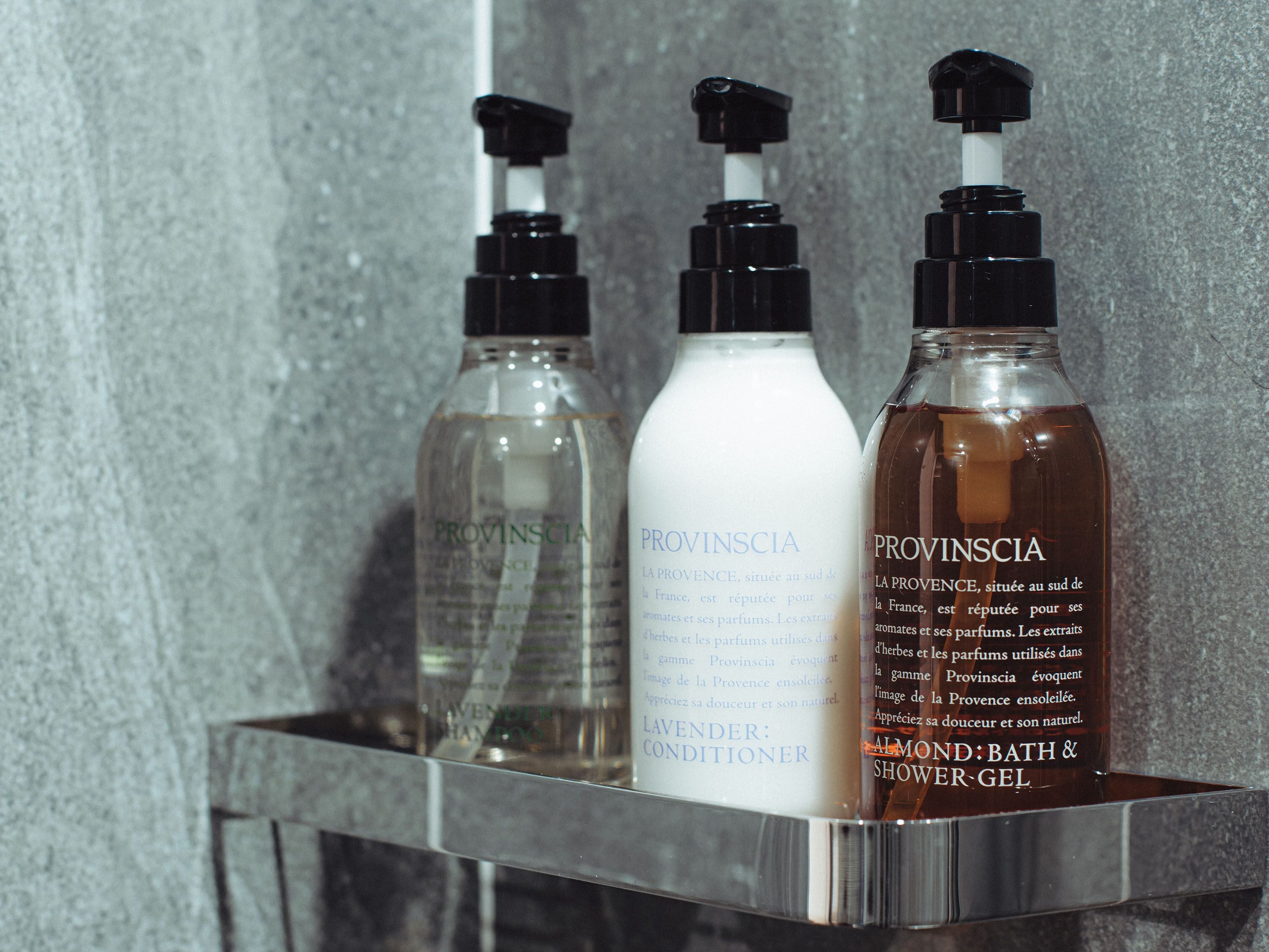 Trois bouteilles de produits de la marque Provinscia sur une étagère de salle de bain.