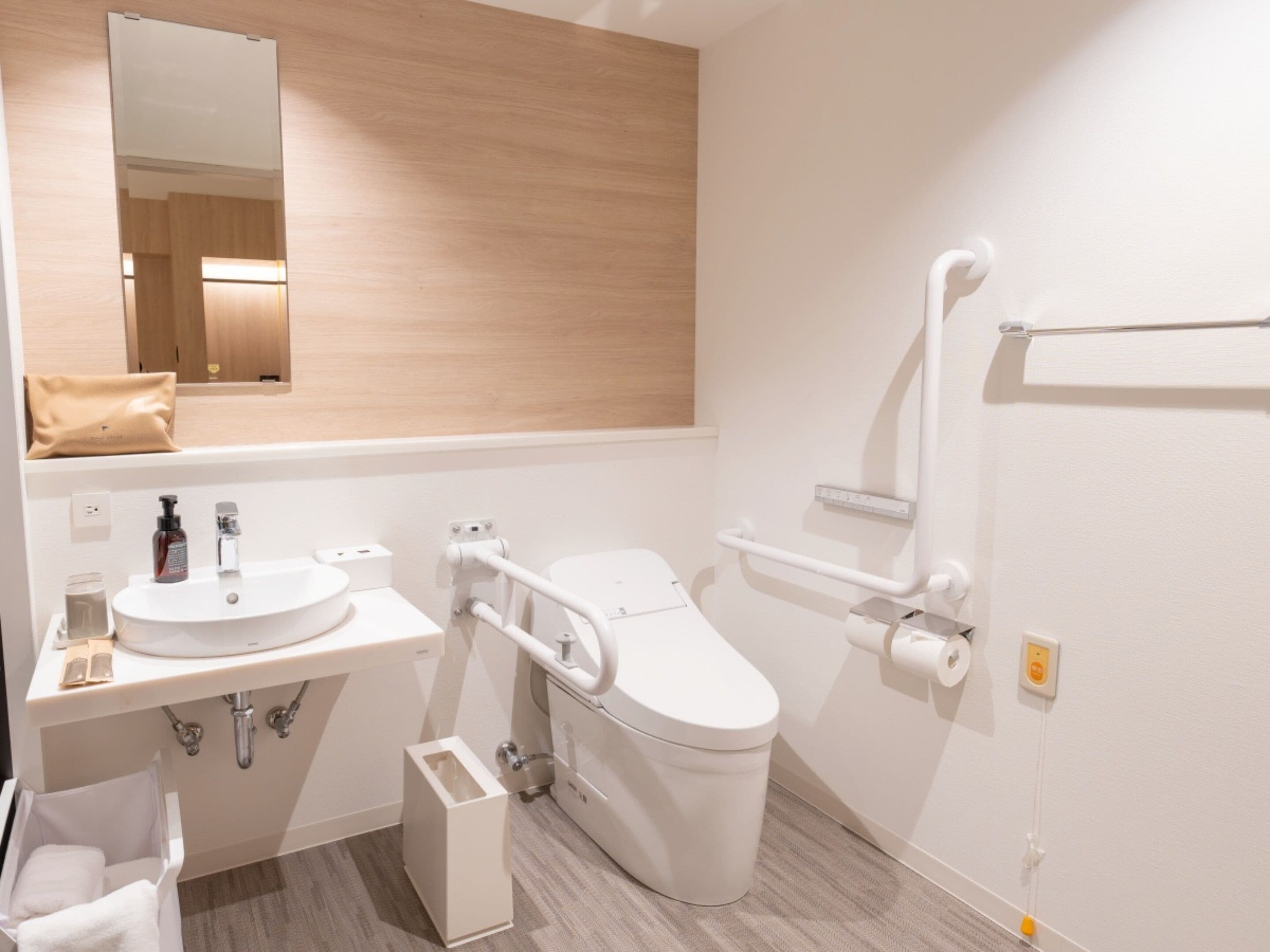A modern bathroom with a sink, toilet, and mirror.