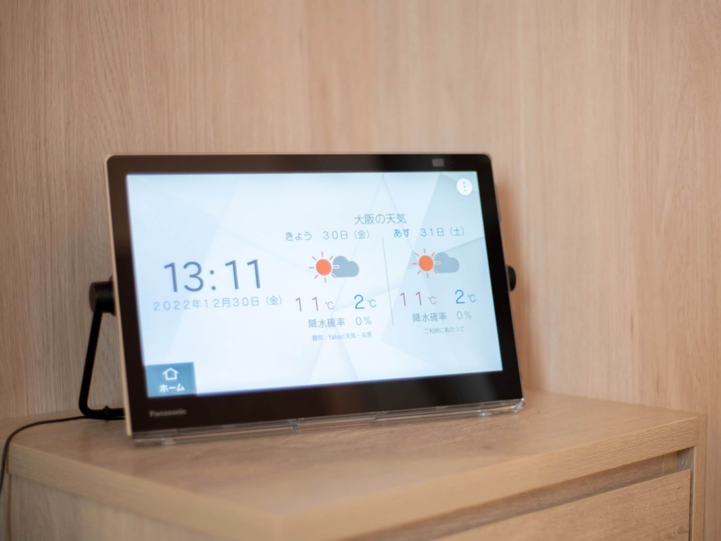Une tablette affichant les prévisions météorologiques sur une surface en bois.