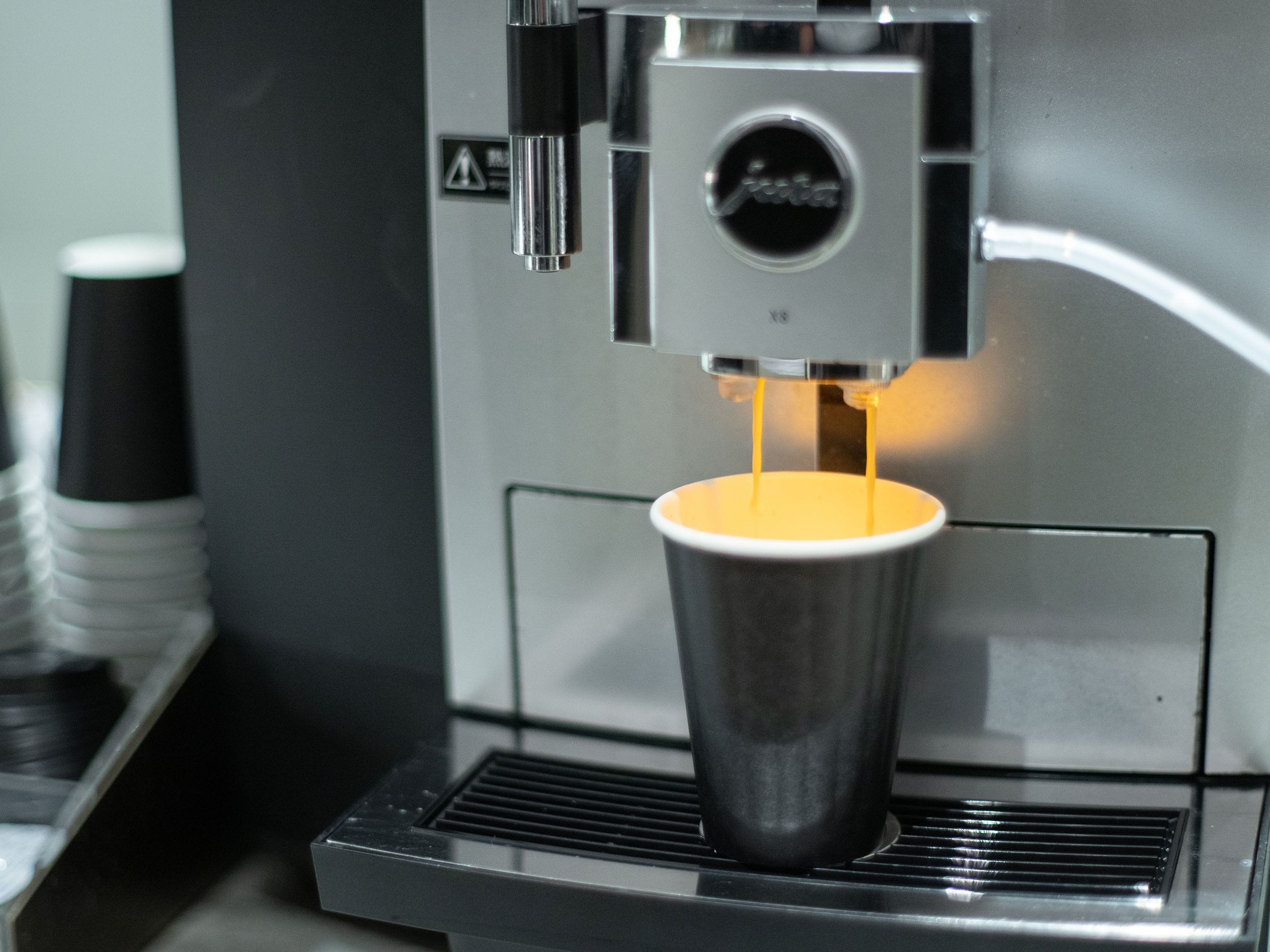 A coffee machine dispensing espresso into a cup.