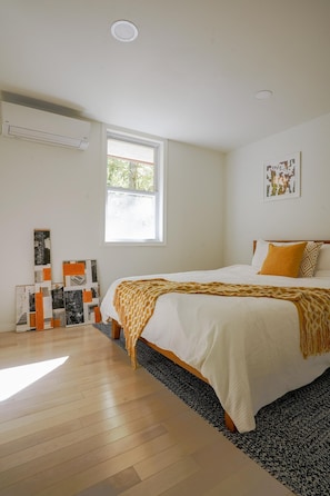 A bedroom with a large bed, a window, and wall art. - Owl's Nest: A Pet-Friendly  Nature Lover's Getaway near Wineries & Hiking Trails (Marlboro)