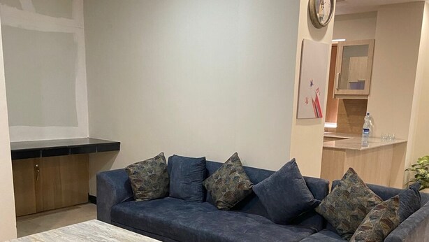 Ein modernes Wohnzimmer mit einer Eckcouch, einem Couchtisch und einer Küche im Hintergrund.
