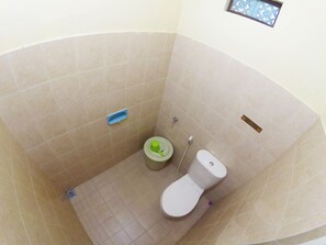 A bathroom with a toilet, a bidet, and a shower area.