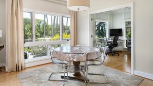 A dining area with a round table, chairs, and a view of the outdoors. - Kiawah Exclusives | 4973 Turtle Point Villa (Kiawah Island)