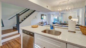 A modern kitchen with a dishwasher, a sink, and a large island.