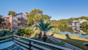 A residential area with a house, a pond, and a clear sky.