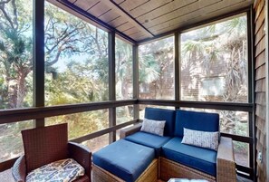 Relax in a serene outdoor space with a bench and wicker chair, surrounded by lush views of the surrounding landscape.