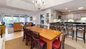 A spacious kitchen with wooden cabinets, a central island, and a dining area with a wooden table and chairs.