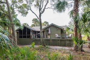 A two-story house with a covered porch and a fenced yard.