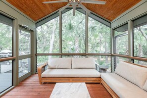 Un intérieur moderne avec un plafond en bois, de grandes fenêtres et un banc en bois.