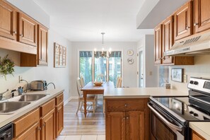 Enjoy cooking in this well-equipped kitchen with a central island, stovetop and oven, double sink, and dishwasher.