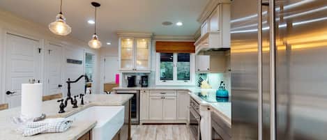Enjoy cooking in this well-lit kitchen with a refrigerator, double sink, and large window.