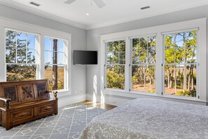 Relax in a serene bedroom with a large bed and stunning views of the surrounding landscape.