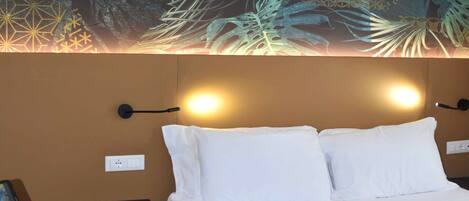 Una habitación de hotel con una cama, un escritorio y un mural en la pared.