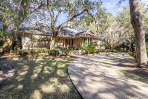 Surrounded by mature trees, this single-story house offers a serene environment and a welcoming entrance.