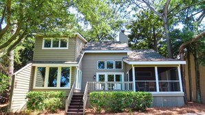 A two-story house with a front porch, a staircase leading to the second floor, and a covered front porch area.
