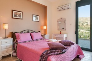 Une chambre à coucher comprenant un lit, des tables de chevet, une commode, un miroir et un appareil de climatisation.