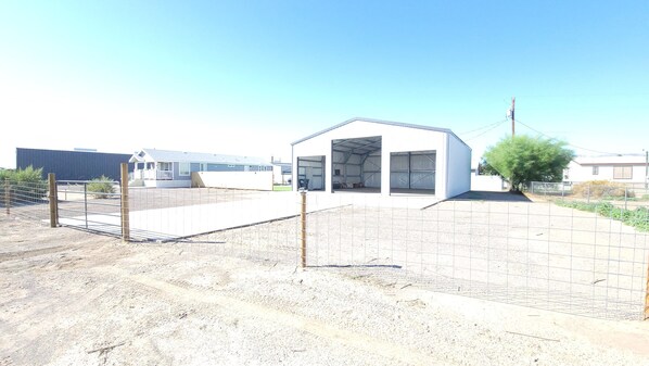 A small, single-story building with a flat roof and a large open garage door.