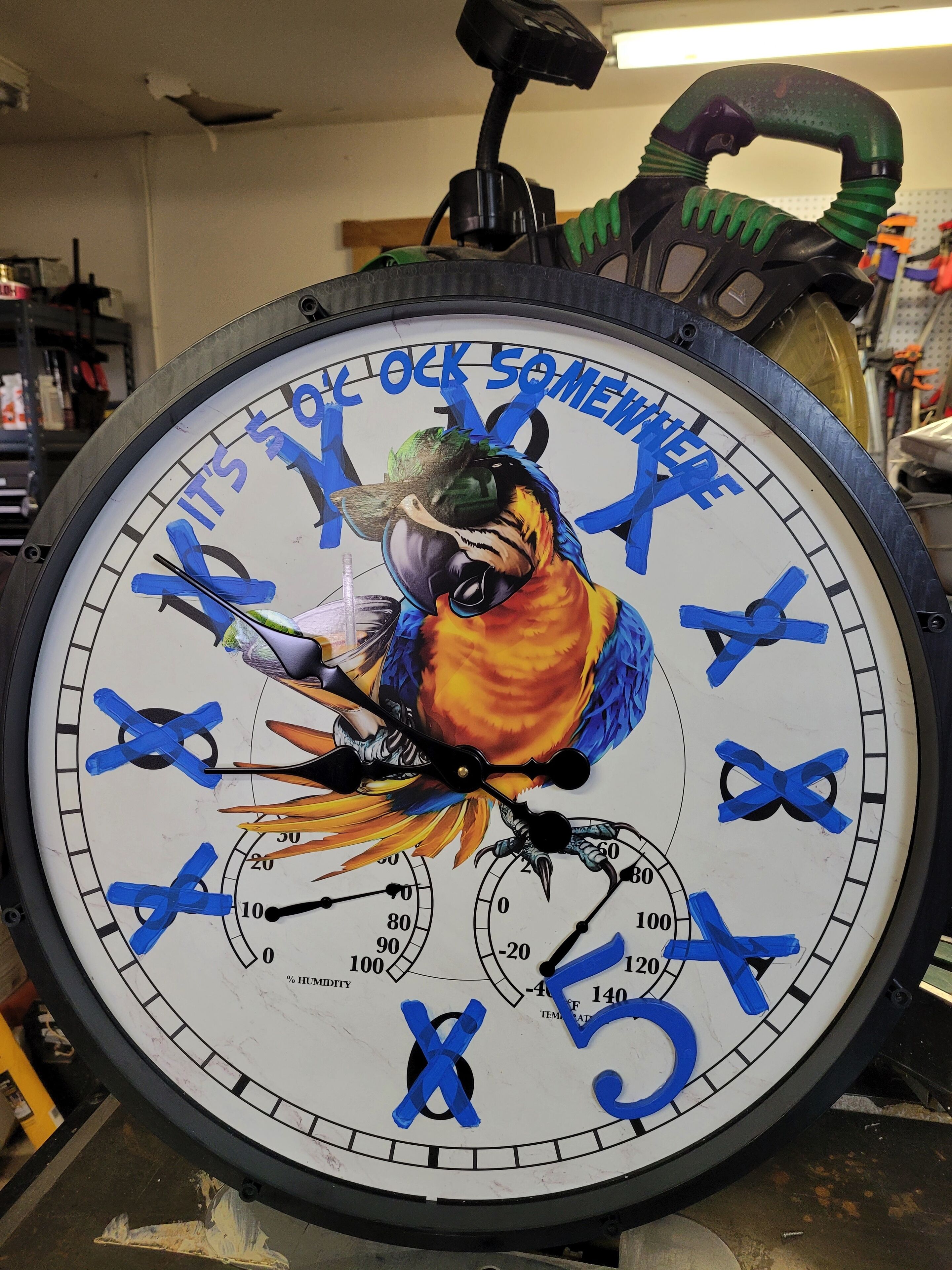 A clock with a colorful parrot design and the phrase "COCK SOMETHING" on its face.
