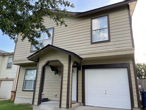 A two-story house with a garage, a covered entryway, and a small porch.