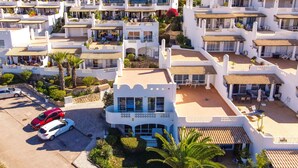 Ein mehrstöckiges Hotel mit Balkonen, Außenbereich und Parkplätzen.