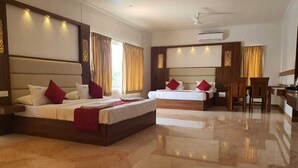 A hotel room with two beds, a sitting area, and a dining table.