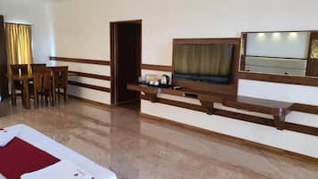 A hotel room with a bed, a desk, a chair, a television, and a mirror.