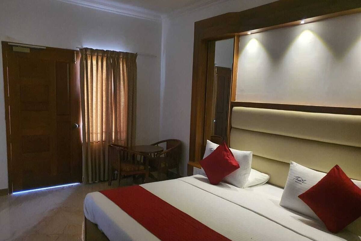 A hotel room with a bed, a desk, and a chair.