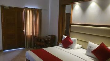 A hotel room with a bed, a desk, and a chair.