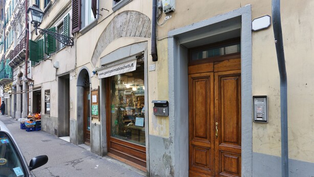 A street view with a restaurant entrance, a wooden door, and a mailbox. - L&D Suites 51, All Saints Square (Firenze)