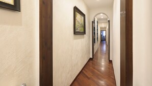 A hallway with wooden flooring, white walls, and framed artwork. - L&D Suites 51, All Saints Square (Firenze)