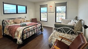 A bedroom with a bed, a chair, and a window with a view. - Riverfront Farm Stay with Animal Nursery at The Hatch Farm, Port Macquarie (Blackmans Point)