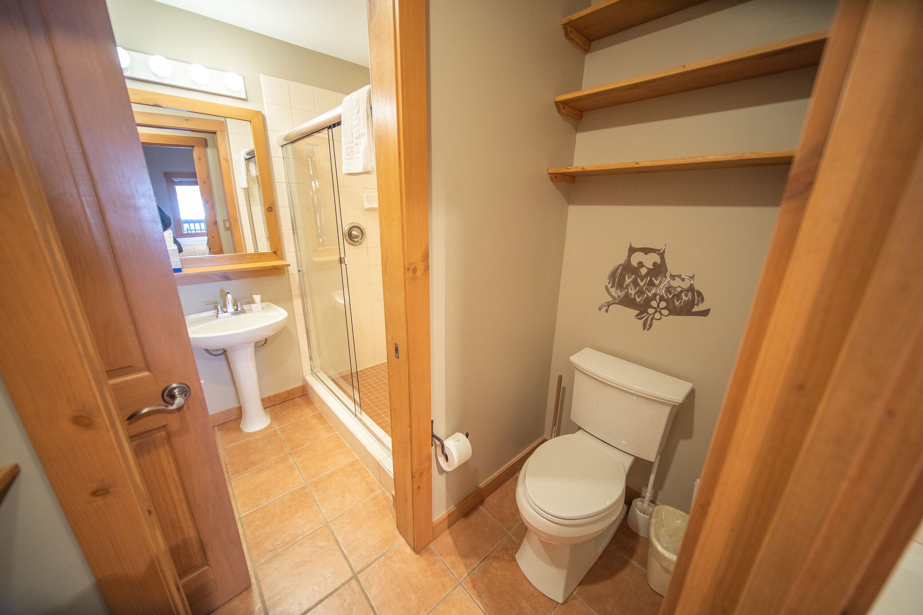 Un baño con inodoro, lavamanos y zona de ducha.
