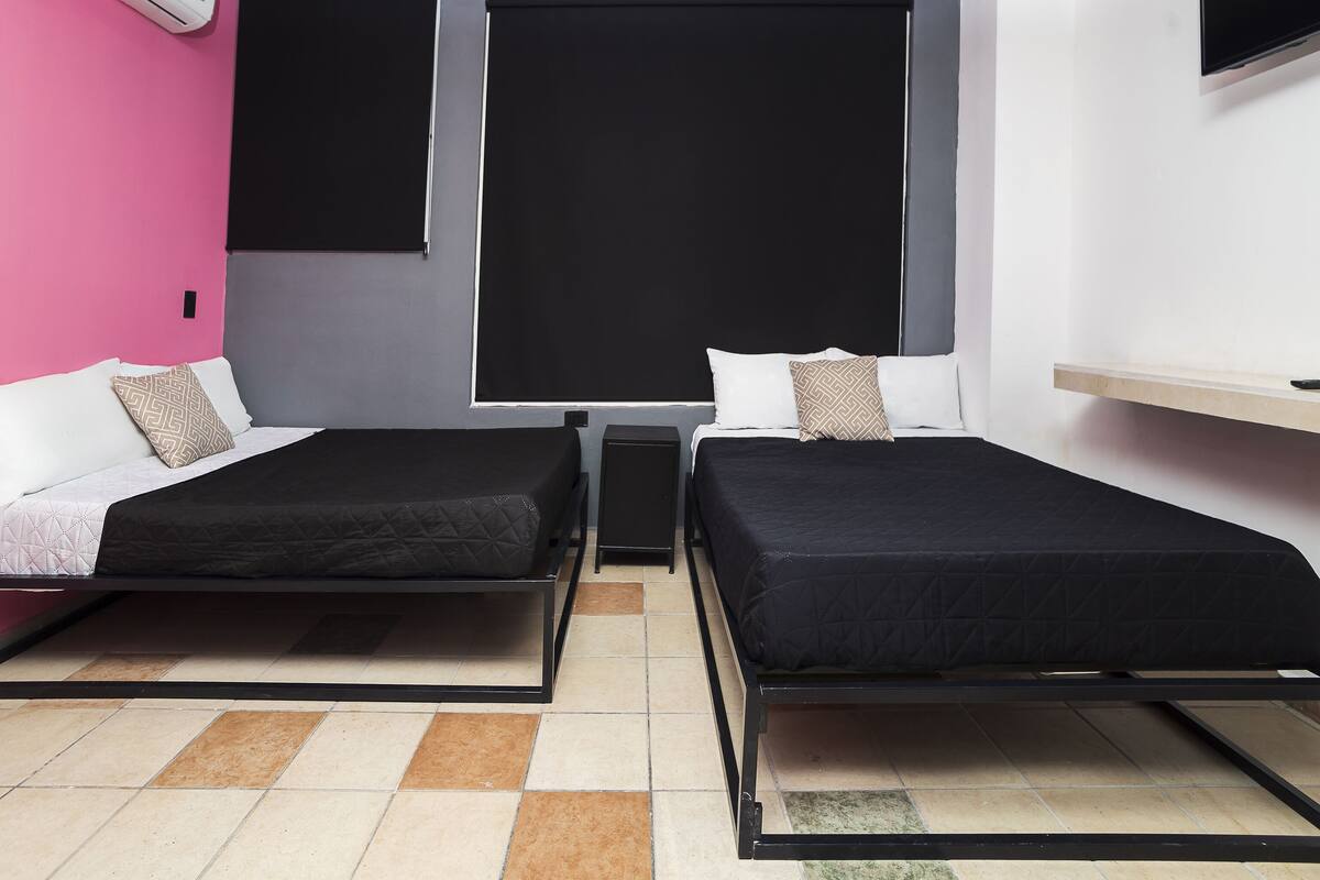 A twin room with two beds, a TV, and a window.